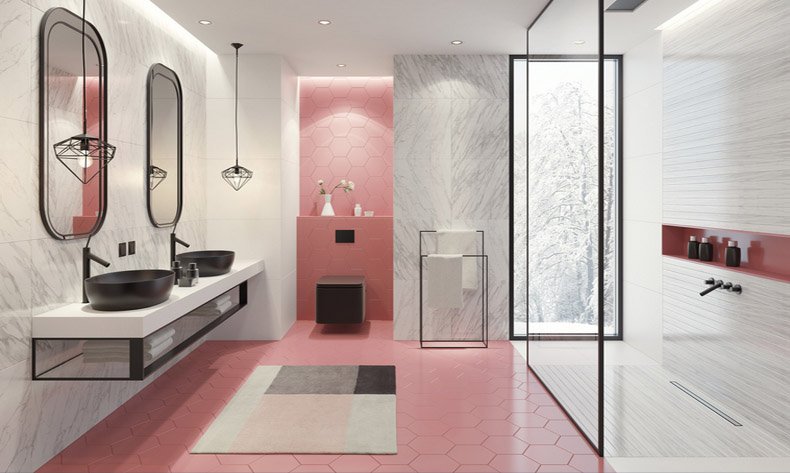 A modern bathroom with pink tiles and a glass shower enclosure.